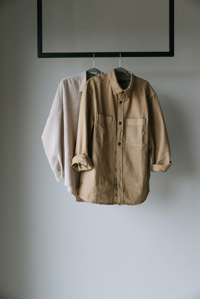 Two neutral shirts hanging on a rack, perfect for minimalist fashion concepts.